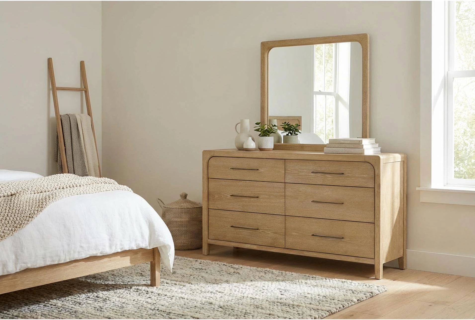 A compact bedroom with a narrow dresser and a tall, slim mirror above it, reflecting soft daylight and making the room feel larger