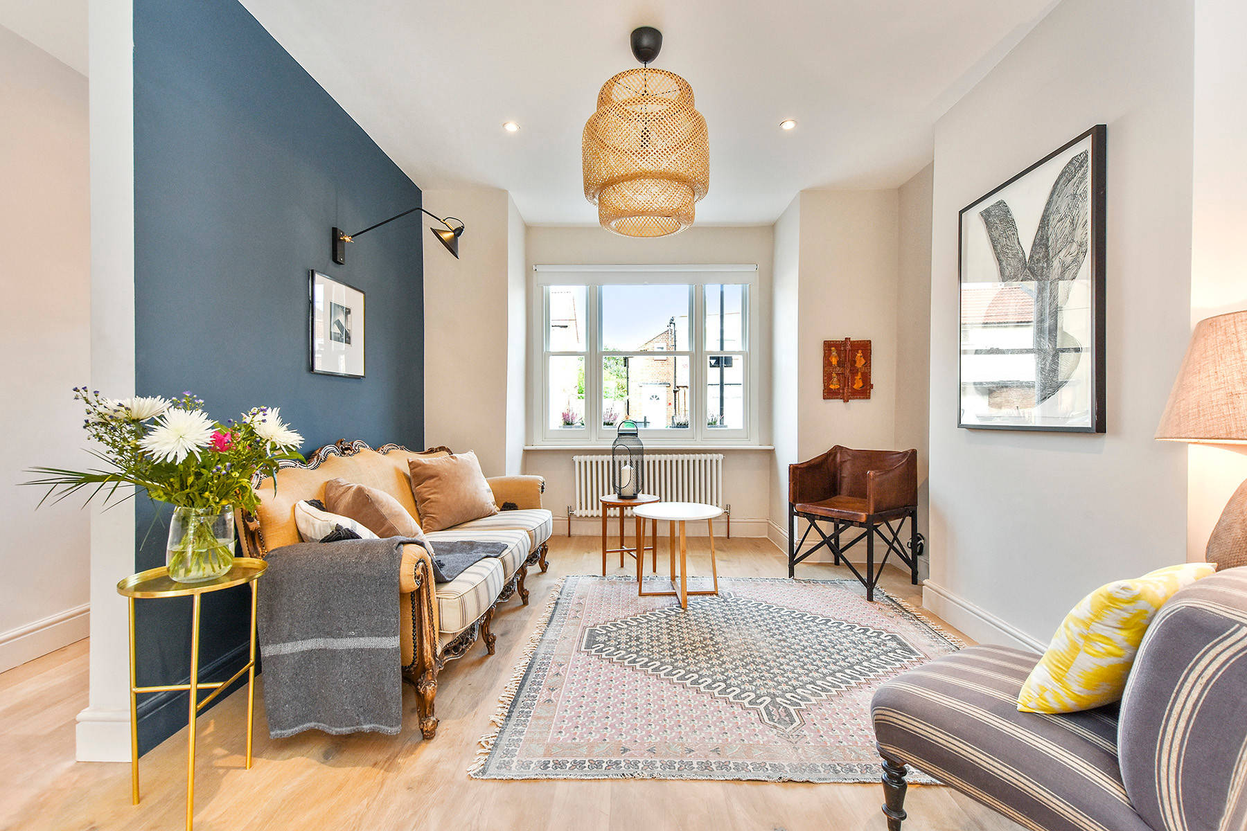 A compact living room with plug-in wall sconces on either side of a small sofa, plus a slim floor lamp tucked into the corner