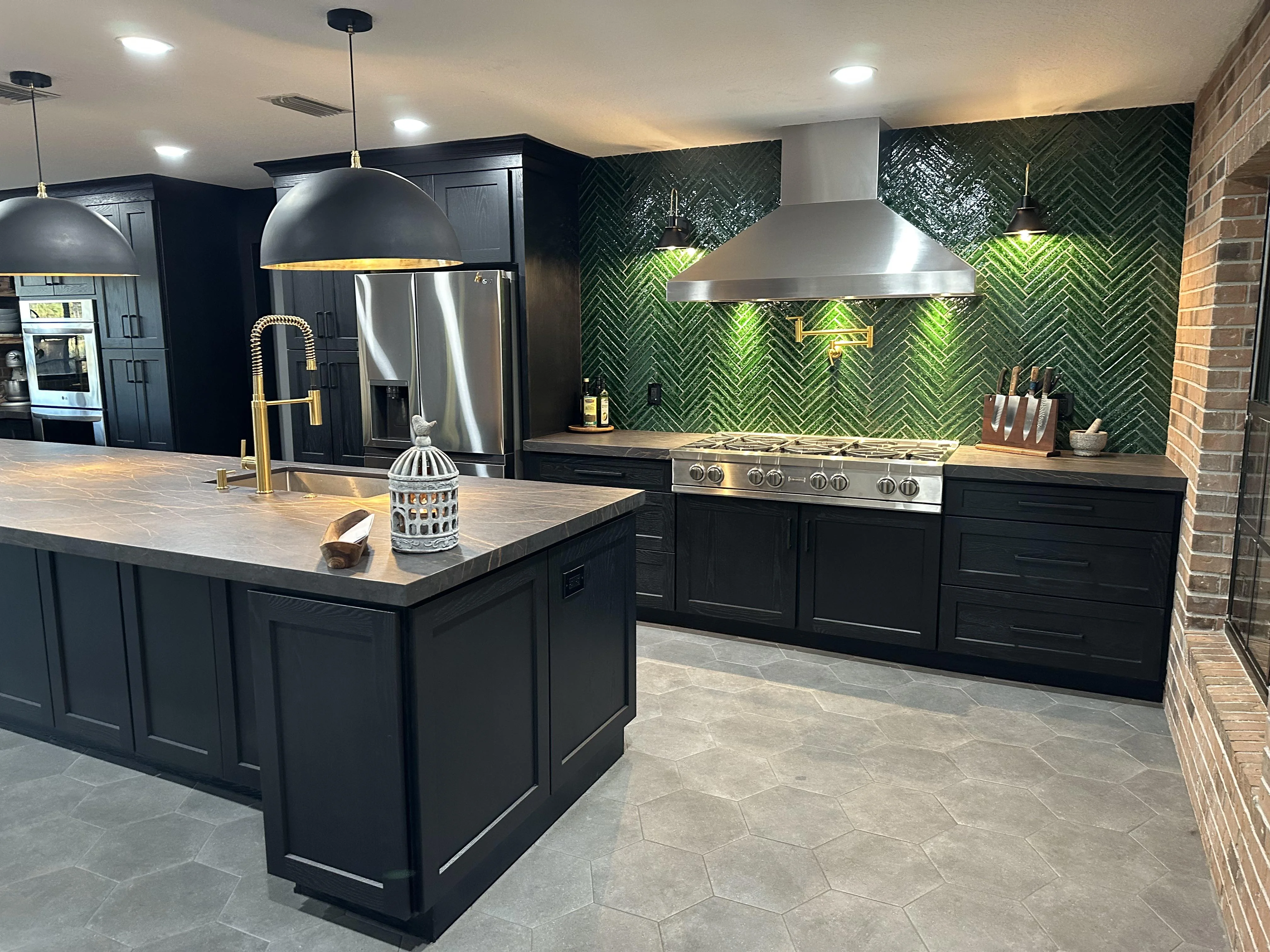 A cozy kitchen with brushed brass cabinet pulls, a matte black faucet, and polished nickel accents on pendant lights