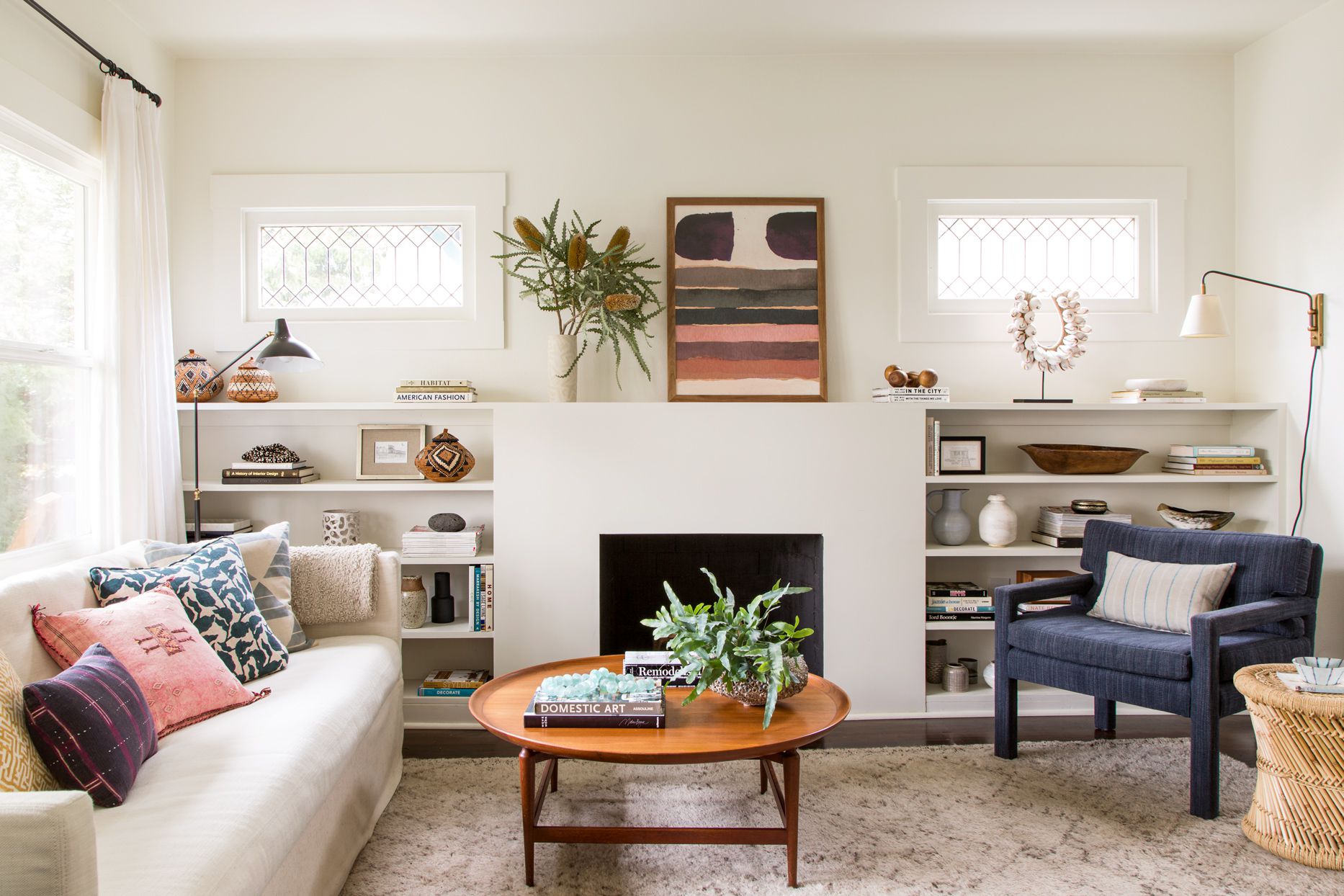 A cozy small living room with a light-colored sofa and a round wooden coffee table centered on a rug, with clear space around it for walking