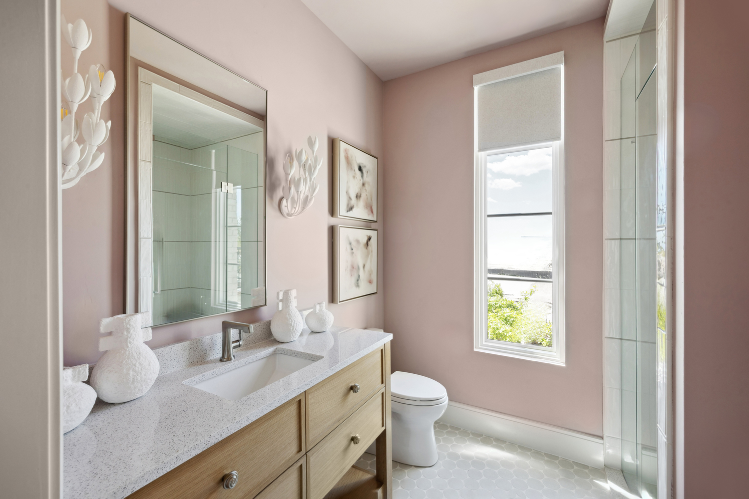 A real small bathroom with a vanity and mirror, painted walls catching soft highlights from overhead lighting