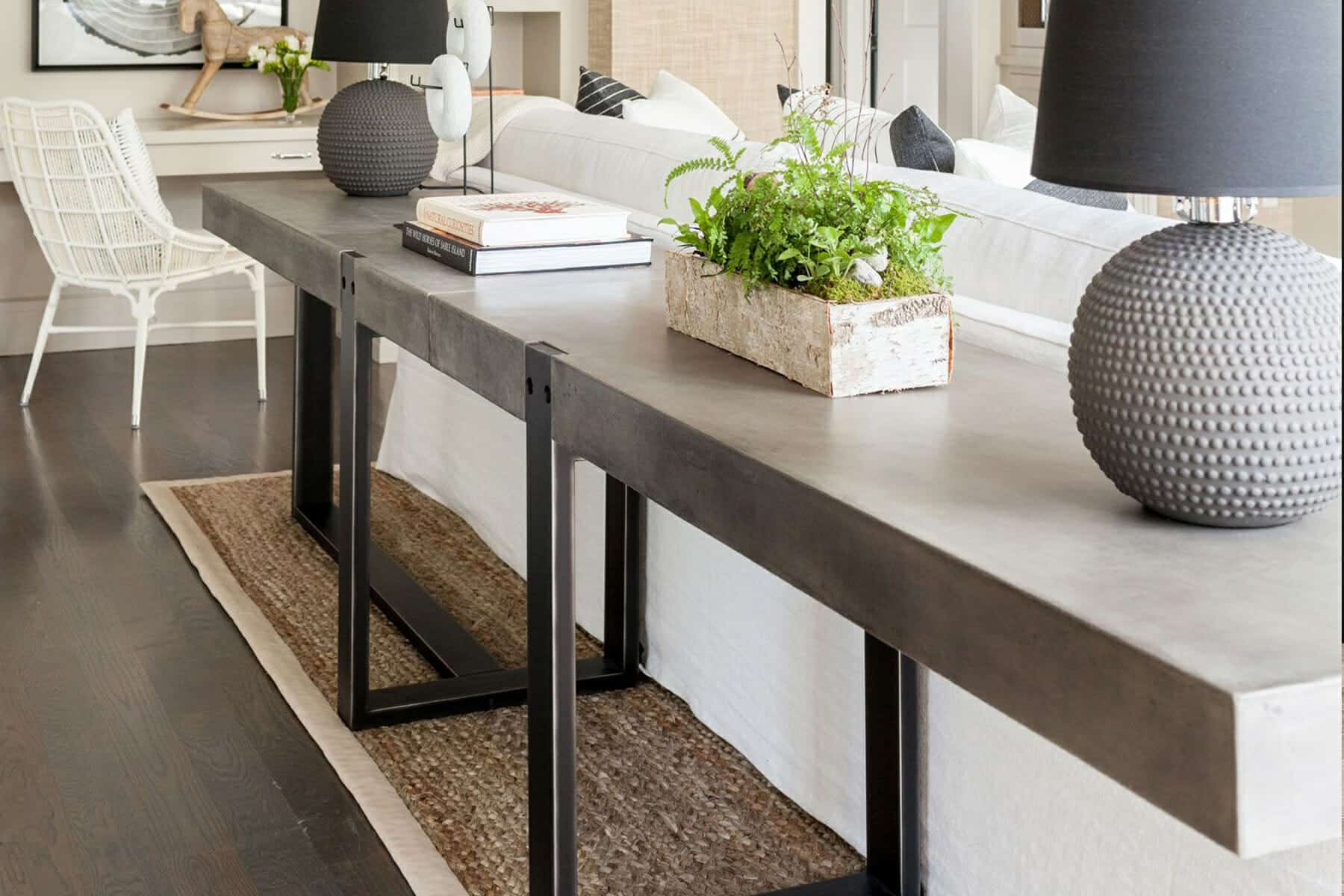 A small living room where a sofa is pulled slightly away from the wall with a narrow console table behind it, creating a more open seating area