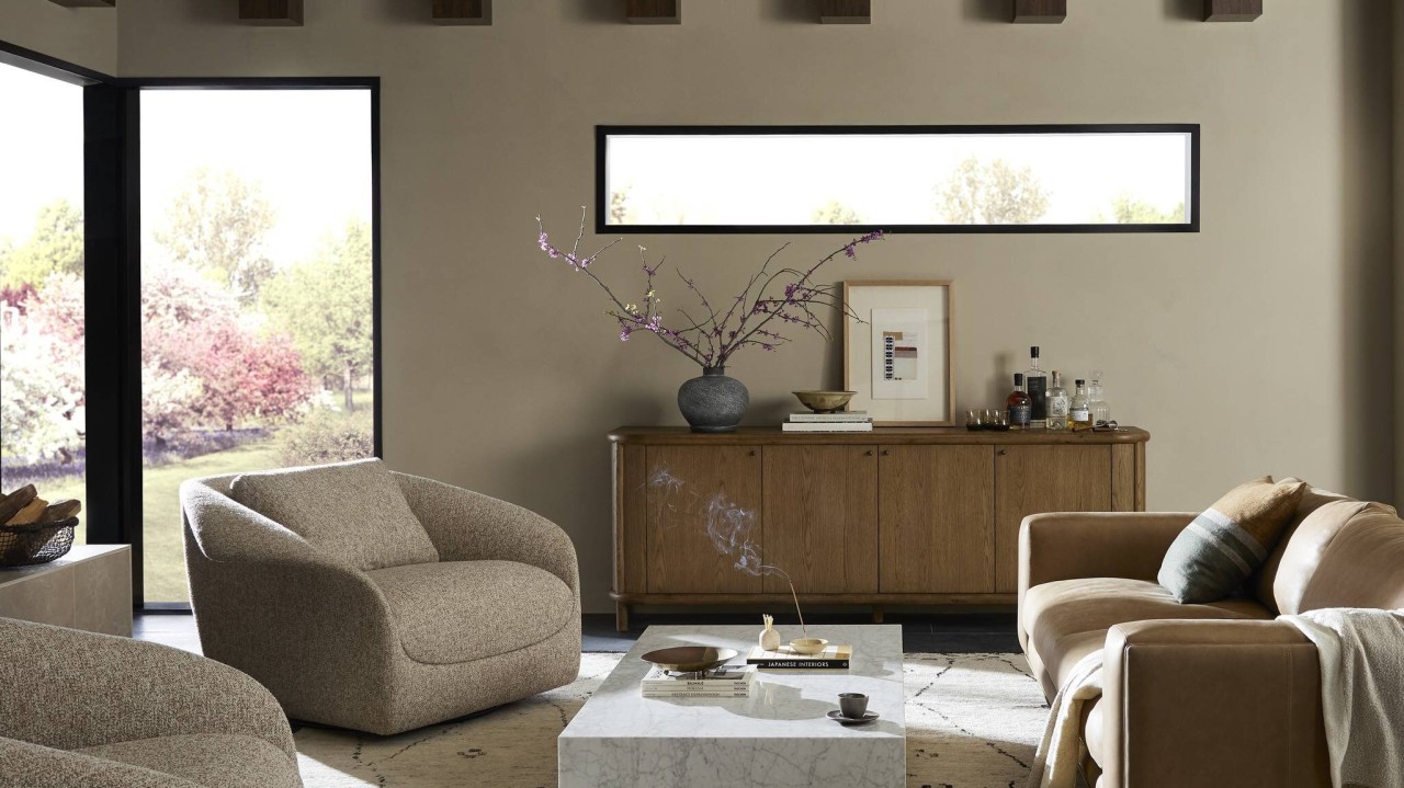 A small living room with an accent chair placed to the side of a sofa, leaving a clear walkway from the doorway to the seating area