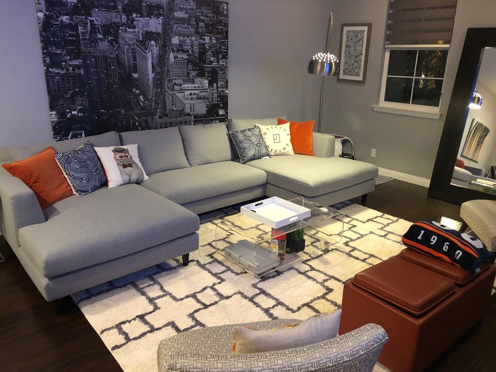 A spacious living room with a U-shaped sectional arranged around a large coffee table on an oversized rug that extends under all seating