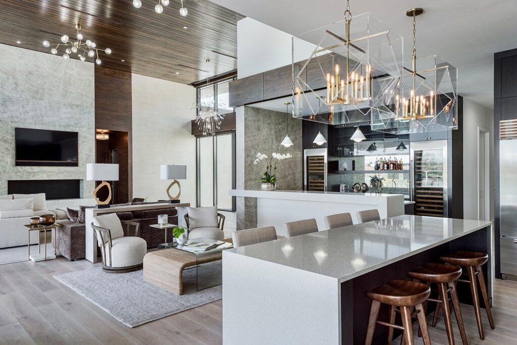 An open-plan space with a pendant light above the seating area, a floor lamp by the sofa, and a small table lamp on a console defining a walkway