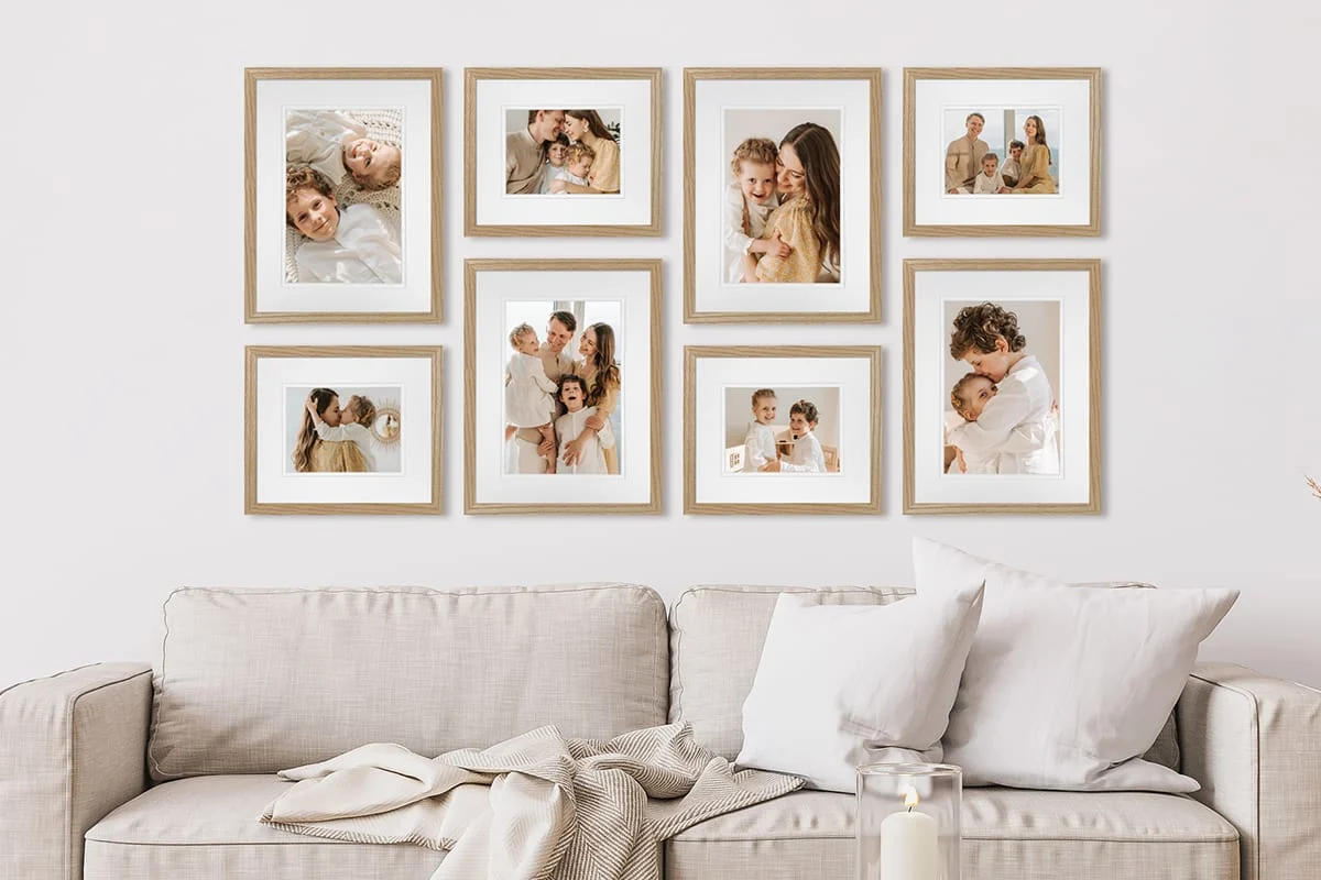 Paper templates taped to a wall in a living room, mapping out a gallery wall layout before hanging frames